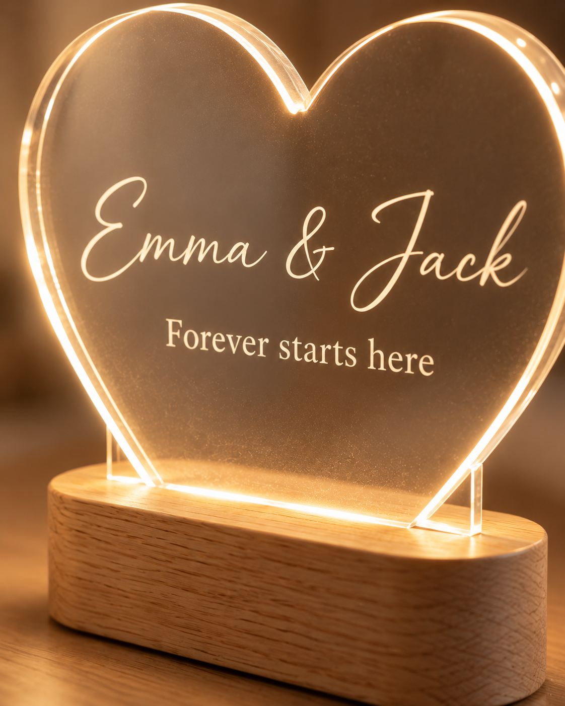 Close-up of the engraved names, LED-lit acrylic edge and oak wood base of the Heart Glow lamp