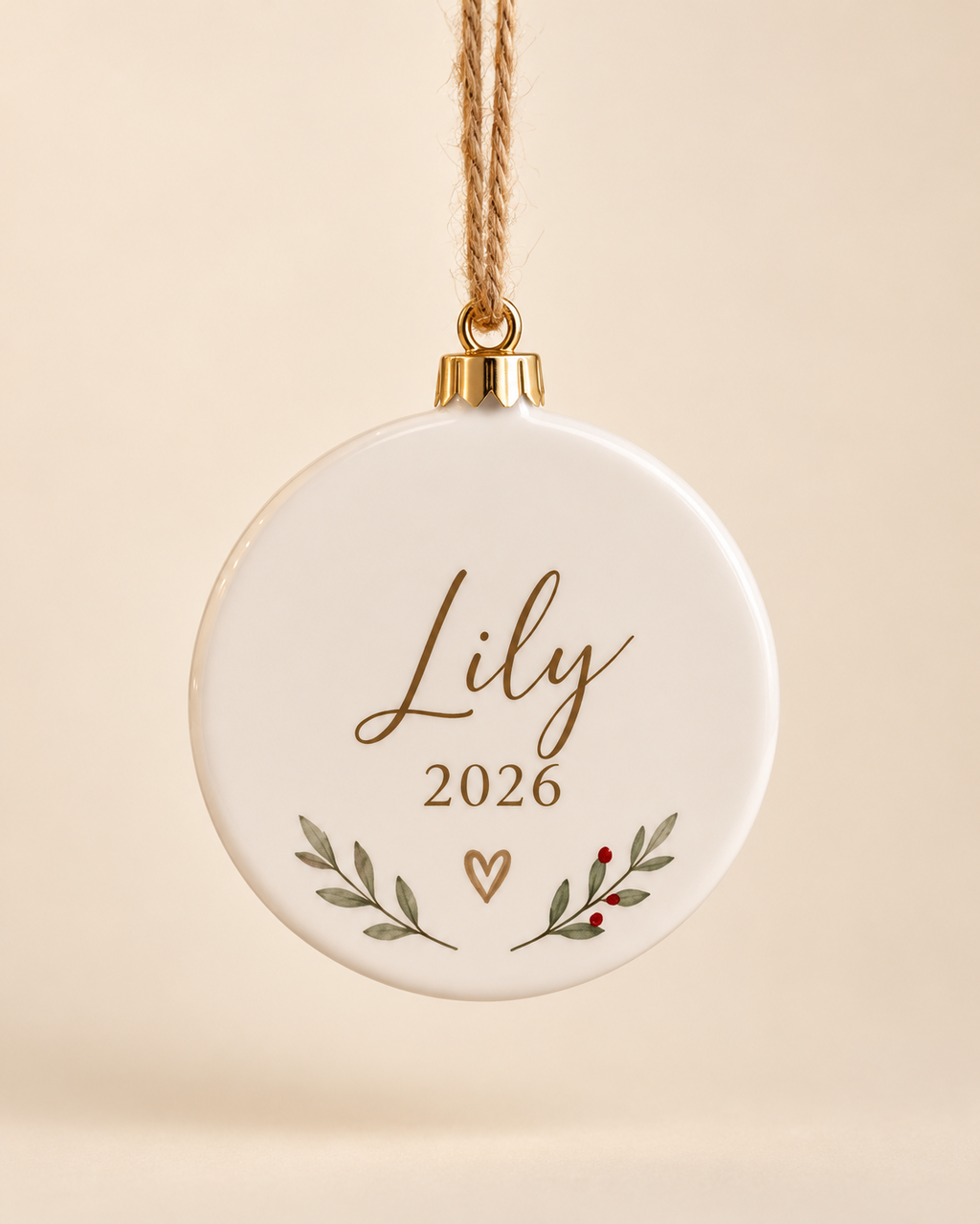 Personalized round ceramic Christmas ornament with name and year on a plain cream background