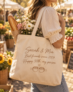 Our Story personalized canvas tote bag with custom names and message, carried at a flower market