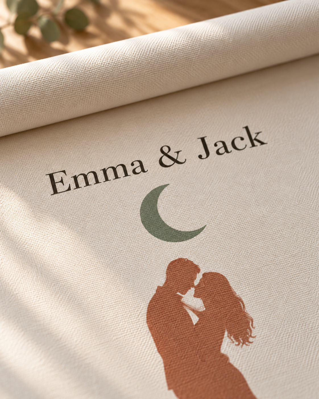 Close-up of the names, green moon and couple silhouette on the personalized canvas texture