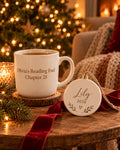 Cozy Christmas gift set: personalized "Olivia's Reading Fuel" mug and "Lily 2026" ceramic ornament on a wooden table with Christmas lights